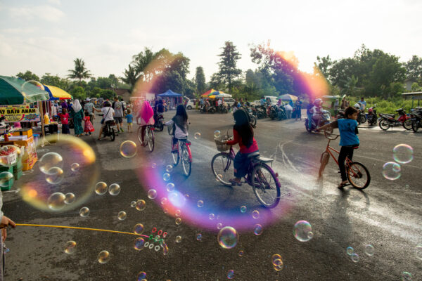 A vendor sells bubbles at the Sunday bazaar at the Bantul City Stadium in Yogyakarta. The bazaar is filled with street vendors selling food, clothing, and traditional Andong (horse cart) rides .  The bazaar happens once a month and sometimes more often depending on the weather and is a great place to get a true local experience.