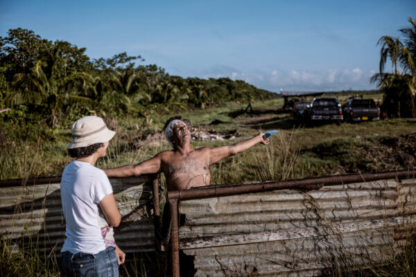 Pool hands out a leaflet about sloths and her organization to a farmer in the outskirts of Paramaribo instructing him where to call if he comes upon a sloth in need of help.