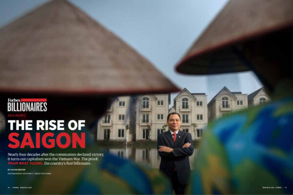 Forbes Asia-Pacific cover image showing a suited man standing with arms crossed in front of a row of beige apartment buildings, framed by blurred foreground leaves, with the headline 'THE RISE OF SAIGON' visible.